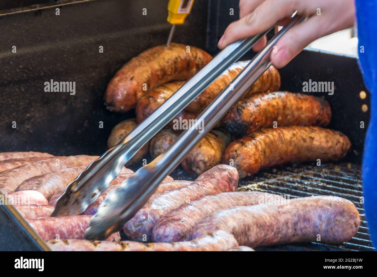 Szenen aus dem Taste of Little Italy Festival. Person, die Hotdogs auf einem Grill mit Zangen kocht. Taste of Little Italy Festival auf der College Street ist ein b Stockfoto