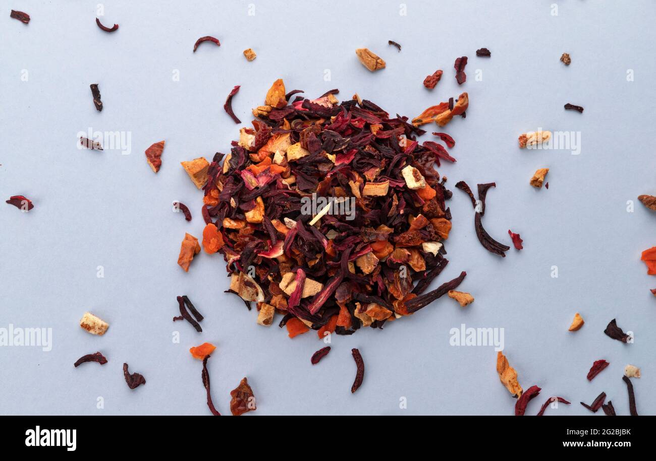 Früchtetee-Blätter isoliert auf weißem Hintergrund, Draufsicht auf trockenen Tee mit Stücken von Früchten und Beeren Stockfoto