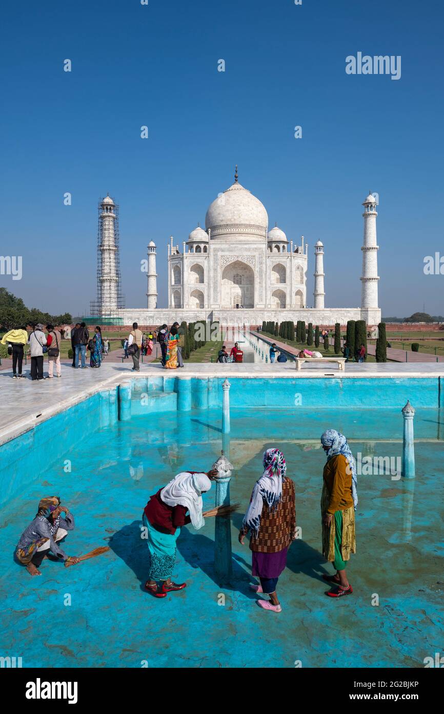 Arbeiterinnen im Prozess der Reinigung eines der Pools im Taj Mahal Komplex als Denkmal für die Öffentlichkeit nach der ersten covid-19 Welle in Indien eröffnet. Stockfoto