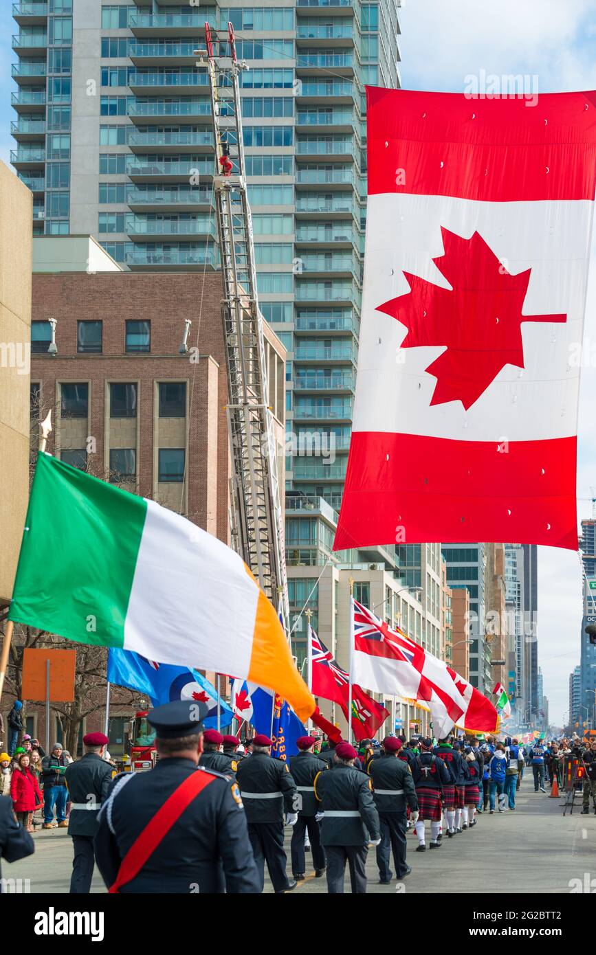 Irische Flagge zusammen mit kanadischer Flagge während der 28. Ausgabe der St. Patrick's Day Parade, die die viertgrößte Feier ihrer Art in der Welt darstellt. Stockfoto