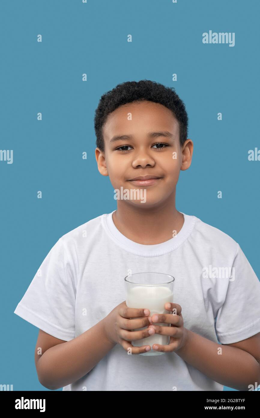Netter freundlicher Junge mit einem Glas Milch Stockfoto