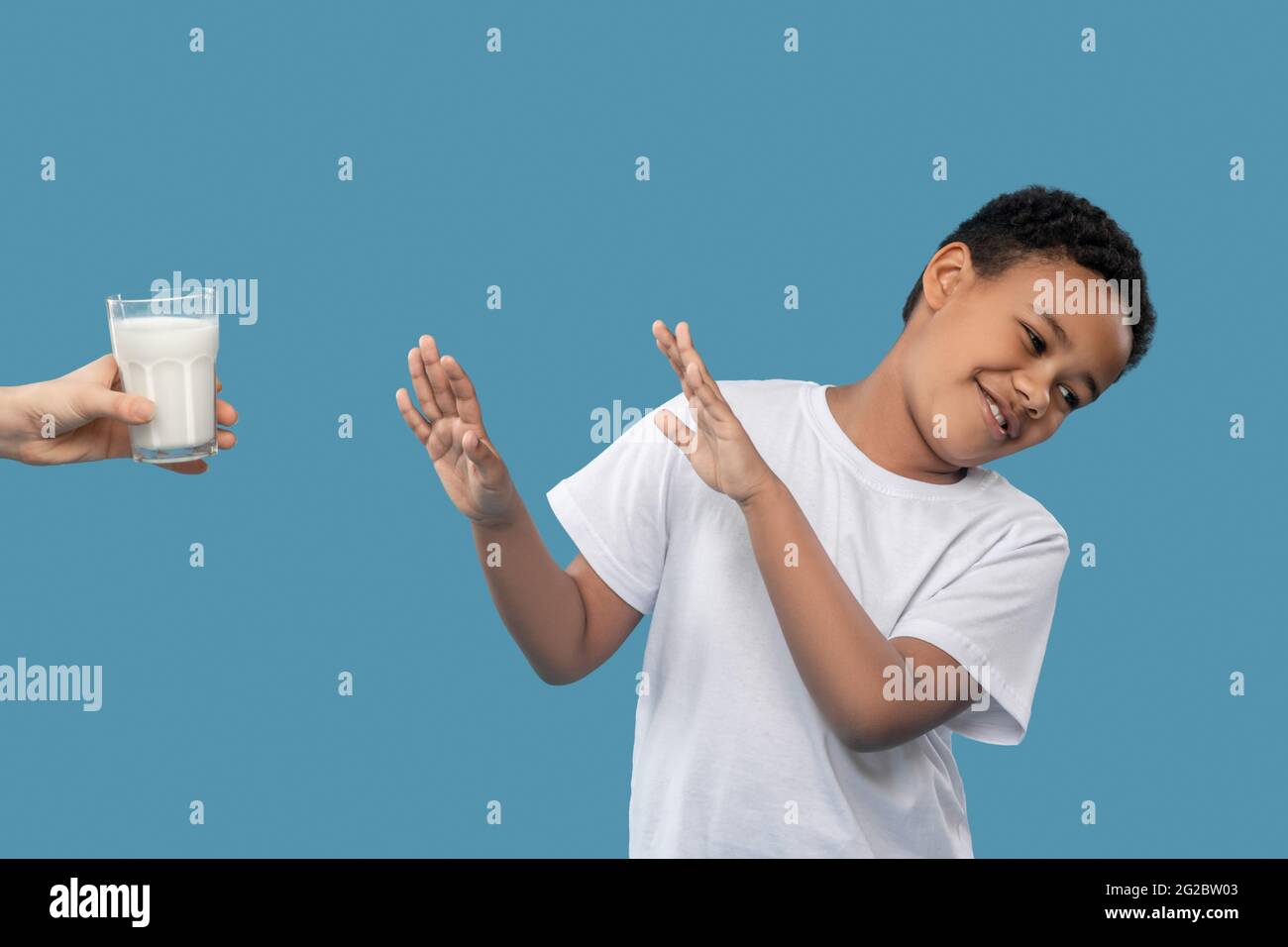 Junge, die sich weigerten, bot ein Glas Milch an Stockfoto