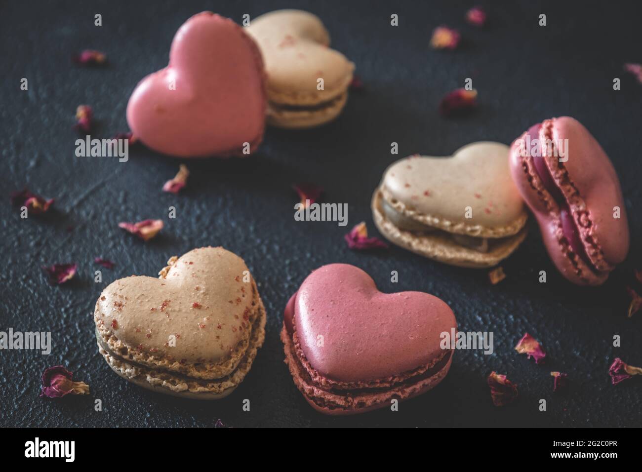 Herzförmige Makronen auf dunkelblauem Hintergrund Stockfoto