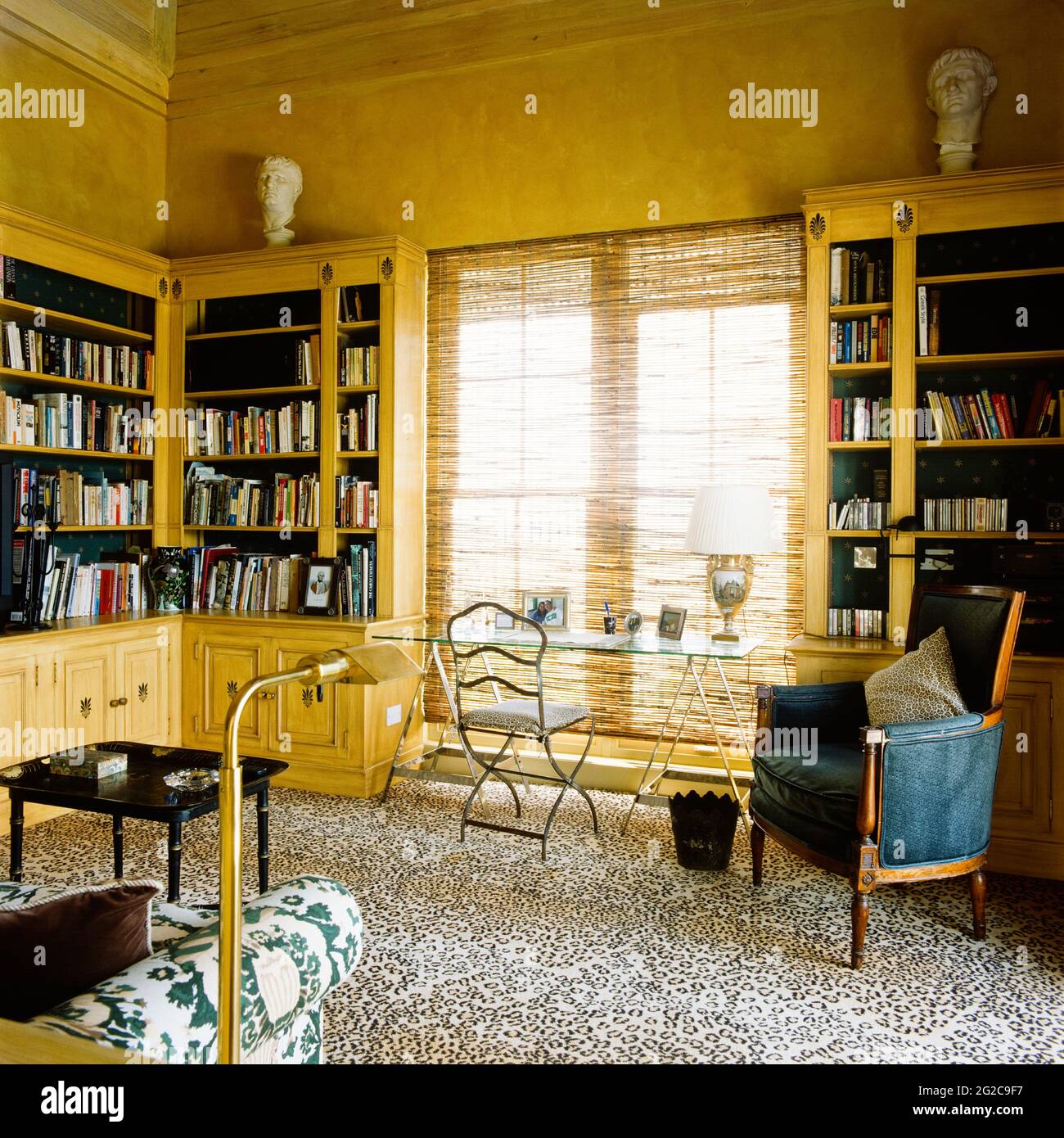 Gelbes Home Office mit Bücherregal Stockfoto