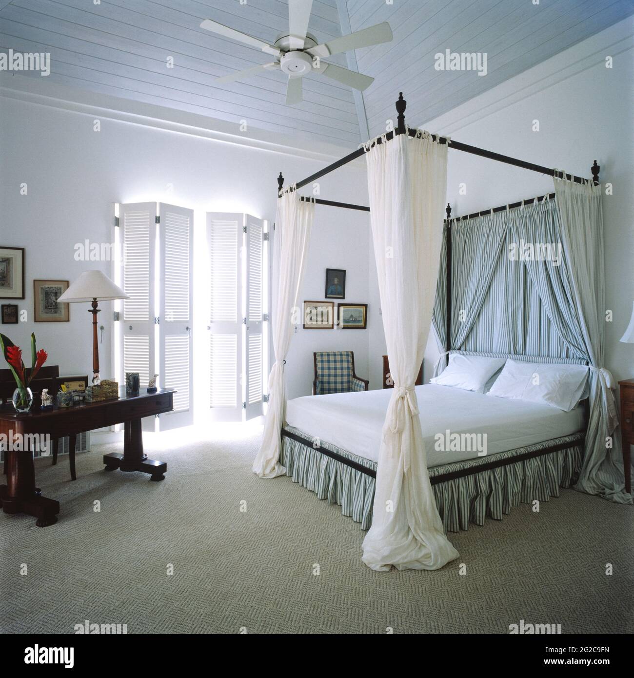 Schlafzimmer mit Himmelbett und Fensterläden Stockfoto