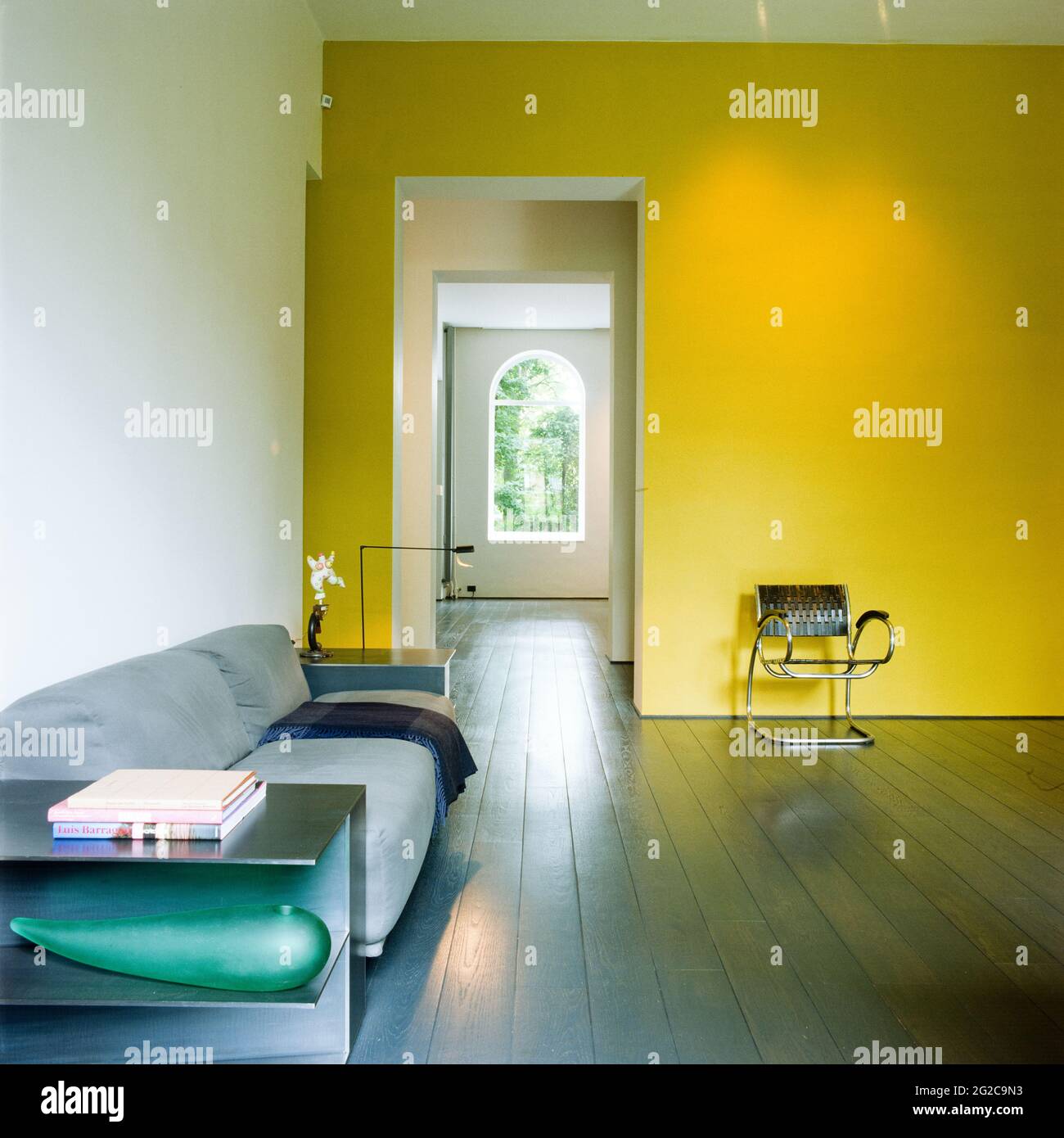 Minimalistisches Wohnzimmer mit gelber Wand Stockfoto