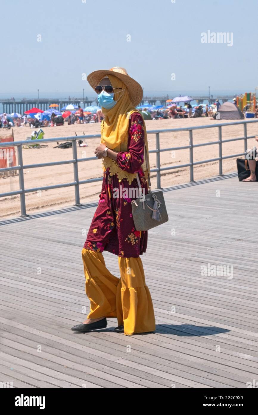 Eine schlanke, bescheiden gekleidete muslimische Frau kommt am Strand von Coney Island, Brooklyn, New York City an. Stockfoto