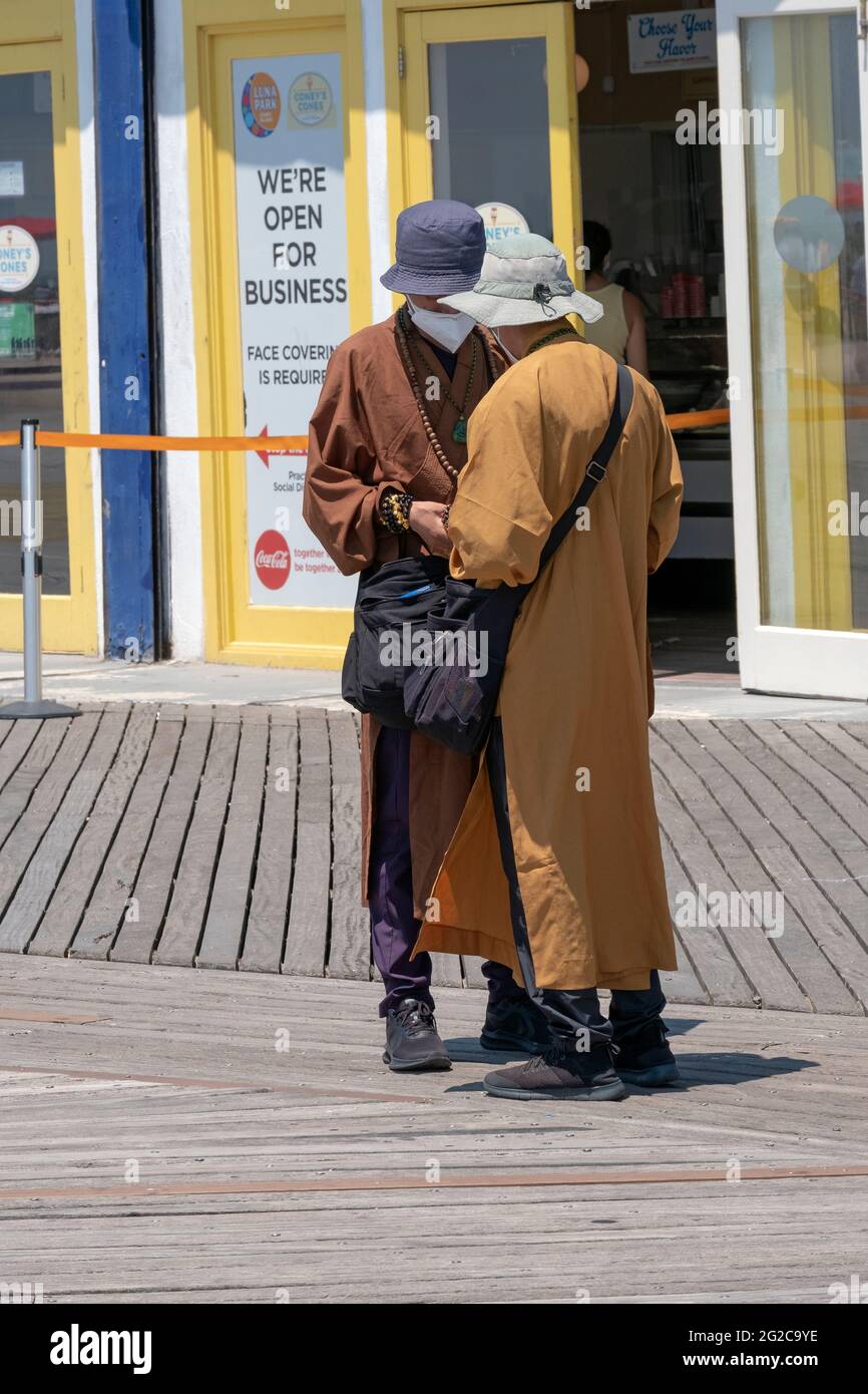In der Nähe eines offenen Geschäftszeichens 2 Männer, die behaupten buddhisten zu sein, zählen ihr Geld vom Verkauf von Armbändern und Büchern. In Coney Island, Brooklyn, New York. Stockfoto