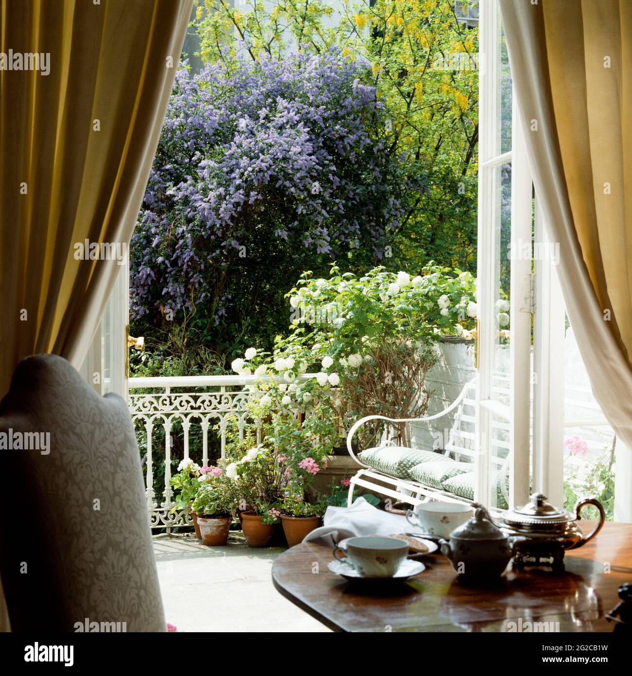 Teeset auf dem Tisch mit Blumentöpfen auf dem Balkon Stockfoto