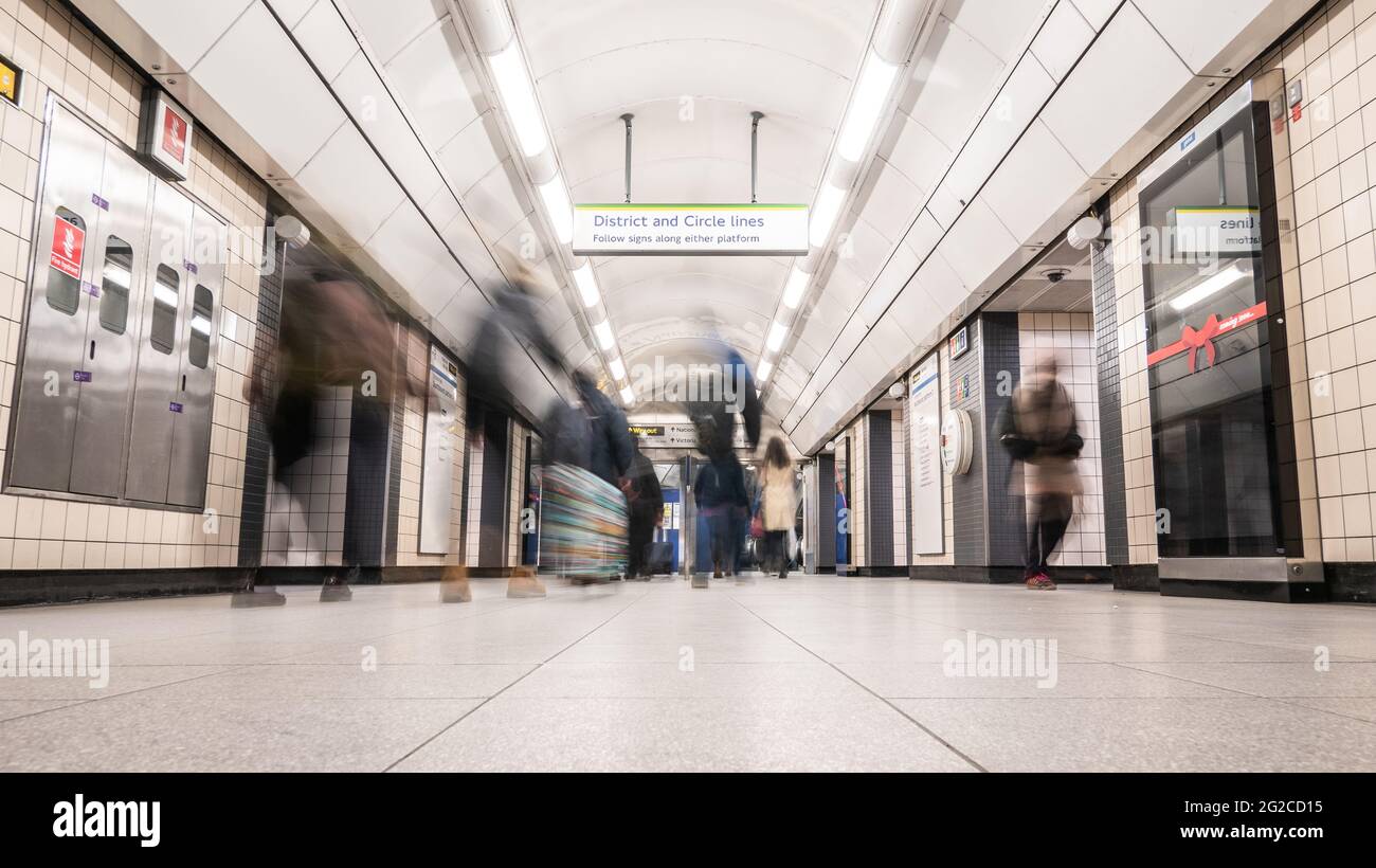 Die Londoner U-Bahn. Lange Belichtungszeit, abstrakte Unschärfe von Passagieren, die an einer U-Bahn-Station zur Fortsetzung ihrer Reise in die Nacht gestiegen sind. Stockfoto