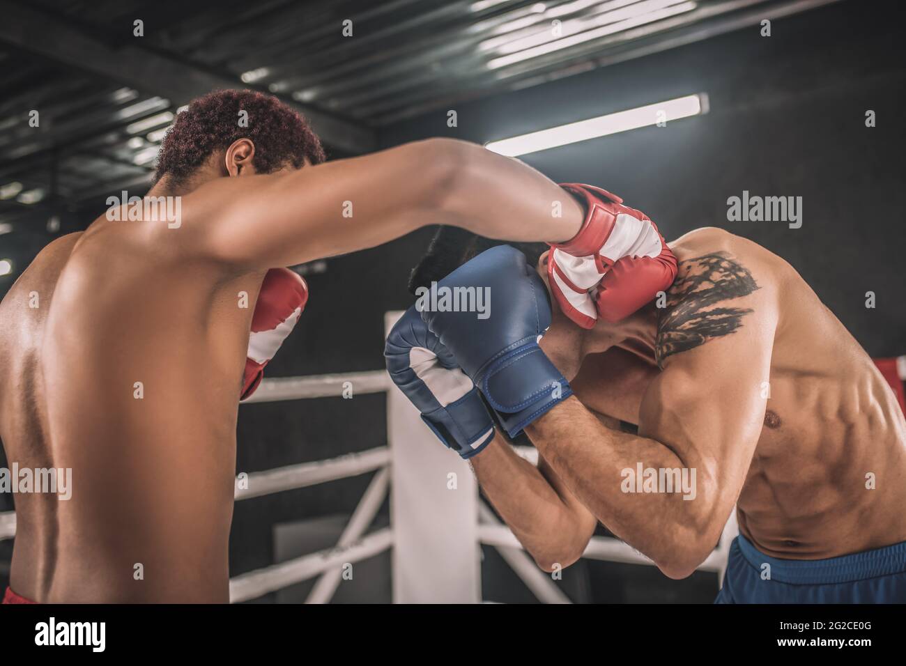 Zwei Kickboxer kämpfen auf einem Boxring und sehen aggressiv aus Stockfoto