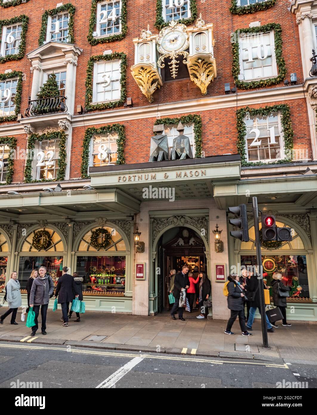 Fortnum und Mason, London. Shopper am Eingang des exklusiven Kaufhauses im Herzen von Piccadilly, das zu Weihnachten dekoriert ist. Stockfoto Fortnum und Mason, London. Shopper am Eingang des exklusiven Kaufhauses im Herzen von Piccadilly, das zu Weihnachten dekoriert ist. Stockfoto