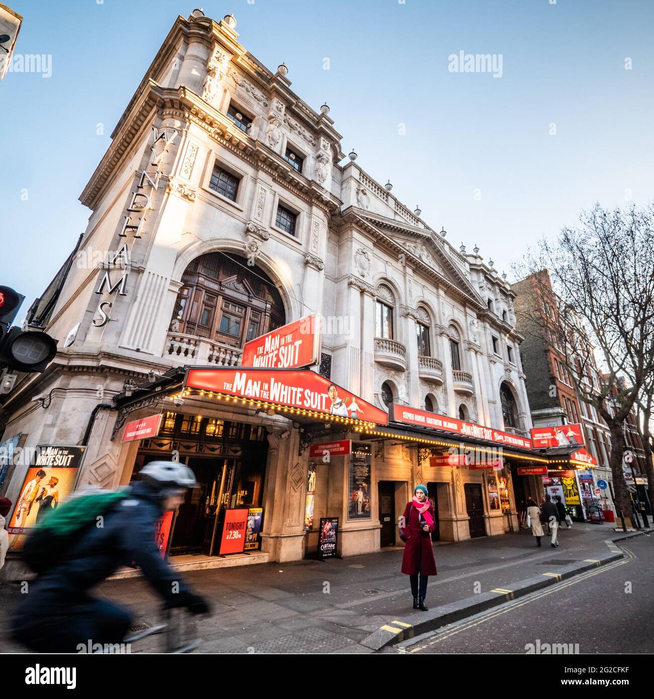 Wyndhams Theatre, London. Niedrige, weite Ansicht der façade zu einem Theater im Londoner West End mit dem Mann im weißen Anzug in der Produktion. Stockfoto