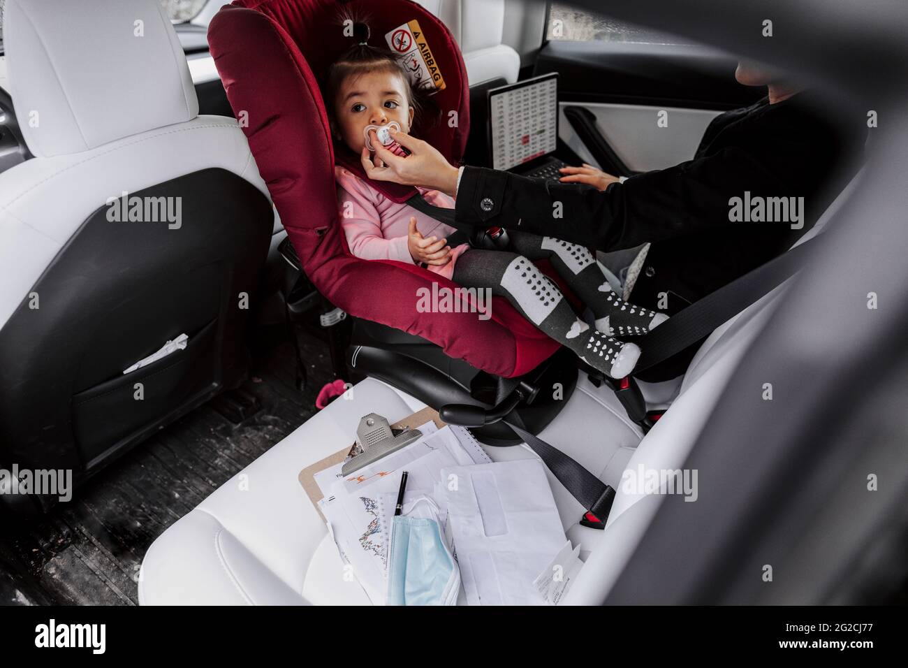 Junge Mutter mit niedlichen kleinen Mädchen Kind im Auto spielen