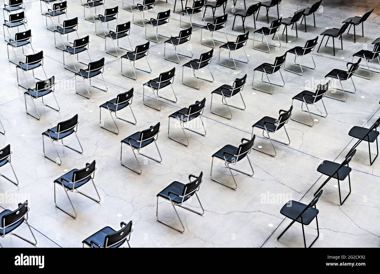 Viele schwarze Stühle, die in der gleichen Entfernung vor der Veranstaltung standen, Muster, abstrakter Hintergrund Stockfoto
