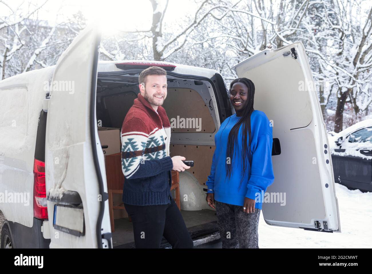 Paar entladen Van im Winter Stockfoto