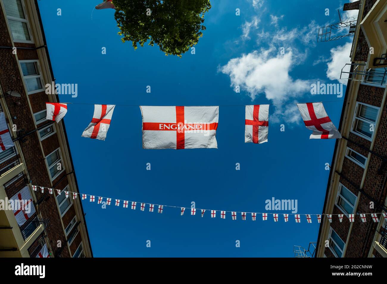 London, Großbritannien. Juni 2021. Fußballverrückte Bewohner des Kirby Estate von Bermondsey im Südosten Londons haben rund 400 englische Flaggen (Kreuz von St. George) vor der Europameisterschaft, die dieses Wochenende beginnt, aufgesetzt und ist in der Tat das Covid-verzögerte 2020-Turnier. Kredit: Guy Bell/Alamy Live Nachrichten Stockfoto