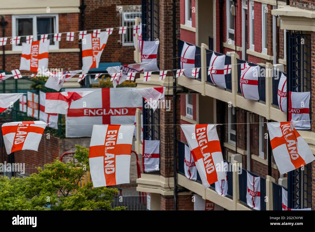 London, Großbritannien. Juni 2021. Fußballverrückte Bewohner des Kirby Estate von Bermondsey im Südosten Londons haben rund 400 englische Flaggen (Kreuz von St. George) vor der Europameisterschaft, die dieses Wochenende beginnt, aufgesetzt und ist in der Tat das Covid-verzögerte 2020-Turnier. Kredit: Guy Bell/Alamy Live Nachrichten Stockfoto