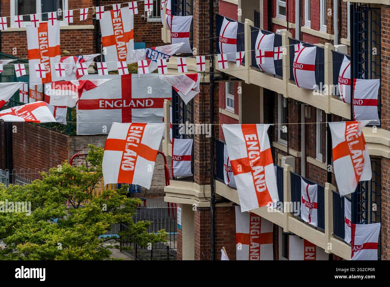 London, Großbritannien. Juni 2021. Fußballverrückte Bewohner des Kirby Estate von Bermondsey im Südosten Londons haben rund 400 englische Flaggen (Kreuz von St. George) vor der Europameisterschaft, die dieses Wochenende beginnt, aufgesetzt und ist in der Tat das Covid-verzögerte 2020-Turnier. Kredit: Guy Bell/Alamy Live Nachrichten Stockfoto