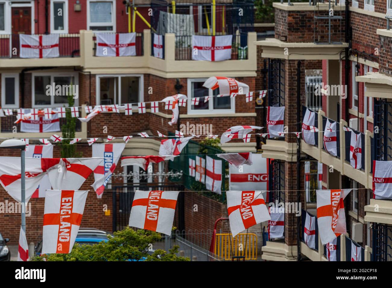 London, Großbritannien. Juni 2021. Fußballverrückte Bewohner des Kirby Estate von Bermondsey im Südosten Londons haben rund 400 englische Flaggen (Kreuz von St. George) vor der Europameisterschaft, die dieses Wochenende beginnt, aufgesetzt und ist in der Tat das Covid-verzögerte 2020-Turnier. Kredit: Guy Bell/Alamy Live Nachrichten Stockfoto