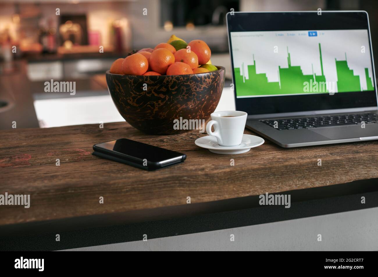 Handy und Kaffeetasse auf der Küchenarbeitsfläche Stockfoto