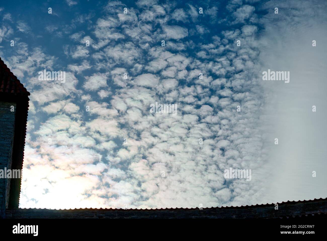 Weiße, flauschige Wolken in der Stadt mit den Umrissen von Häusern. Cloud Zeitraffer Natur Hintergrund Stockfoto