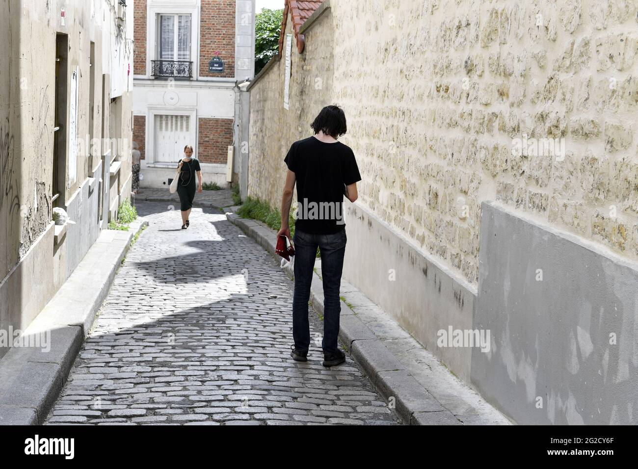 eine Kopfsteinpflaster-Sackgasse mit Backsteinhäusern und Steinmauern, die wie Villa Léandre in Montmartre, Paris, aussieht Stockfoto