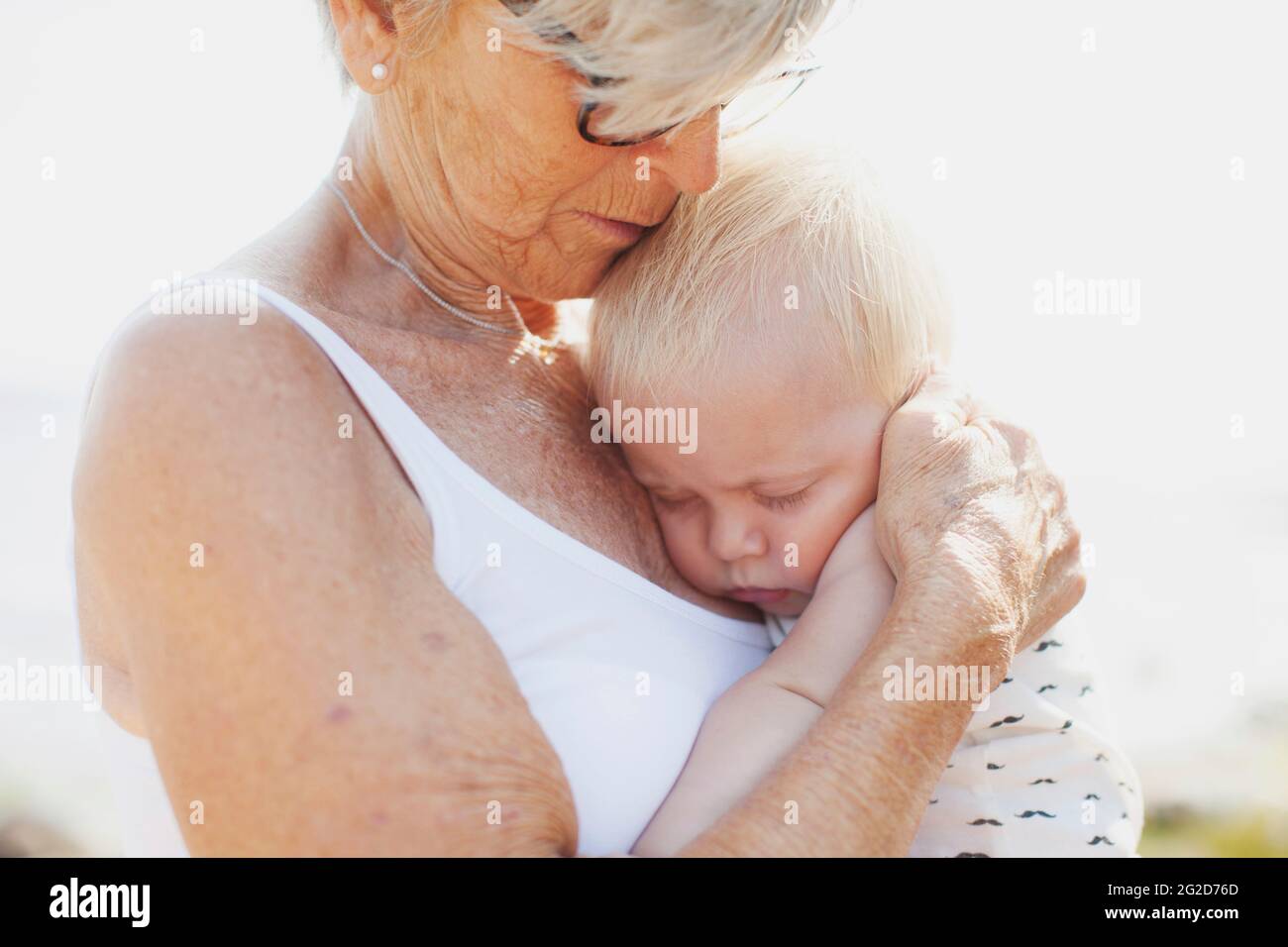 Großmutter umarmte schlafenden Enkel Stockfoto
