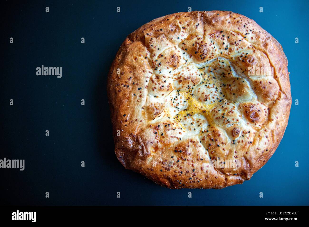 Traditionelles, berühmtes türkisches Brot-Foto, das im heiligen Monat Ramadan gebacken wurde und in der Türkei als „Pide“ bekannt ist. Isolierte runde Pizza mit Sesam. Fladenbrot Stockfoto