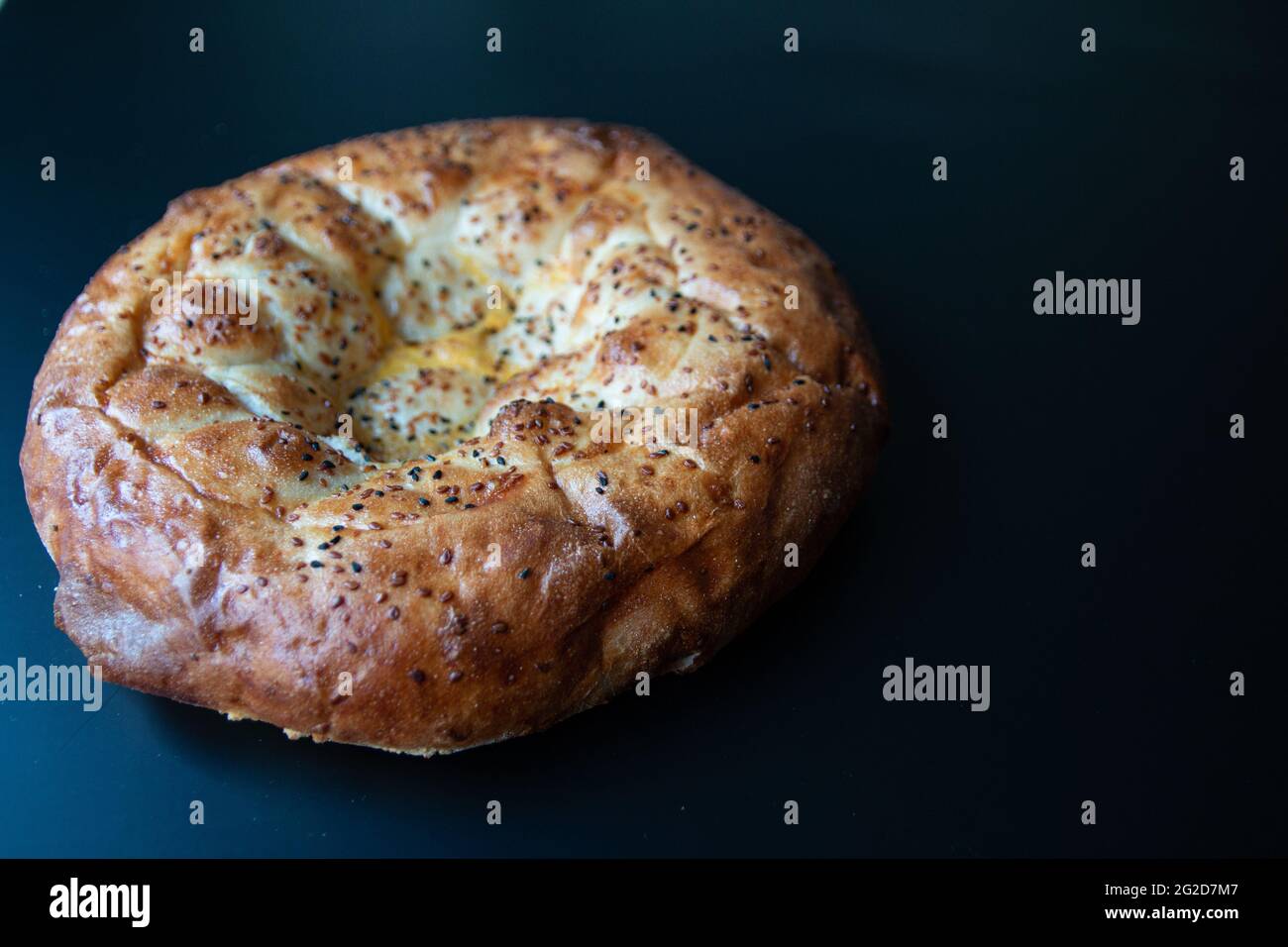 Traditionelles, berühmtes türkisches Brot-Foto, das im heiligen Monat Ramadan gebacken wurde und in der Türkei als „Pide“ bekannt ist. Isolierte runde Pizza mit Sesam. Fladenbrot Stockfoto