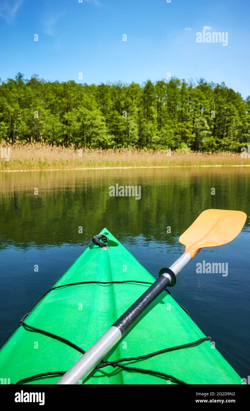 Paddeln Sie auf einem Bogen eines grünen Kajaks im Wasser, selektiver Fokus. Stockfoto