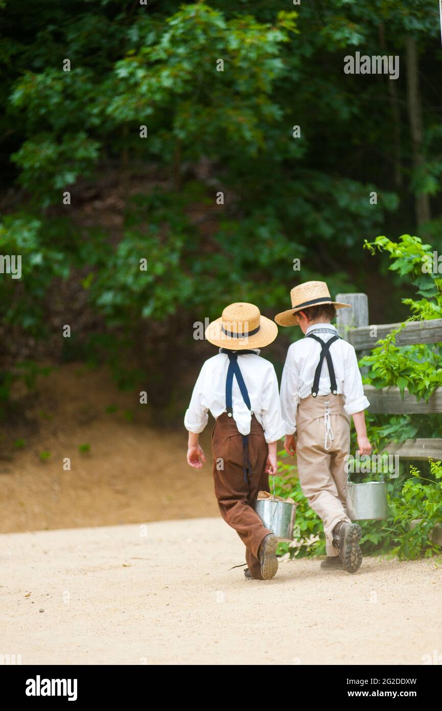 Zwei Jungen in der Zeit Kostüm Wandern mit Mittagessen Eimer, Old Sturbridge Village, Sturbridge, Massachusetts Stockfoto