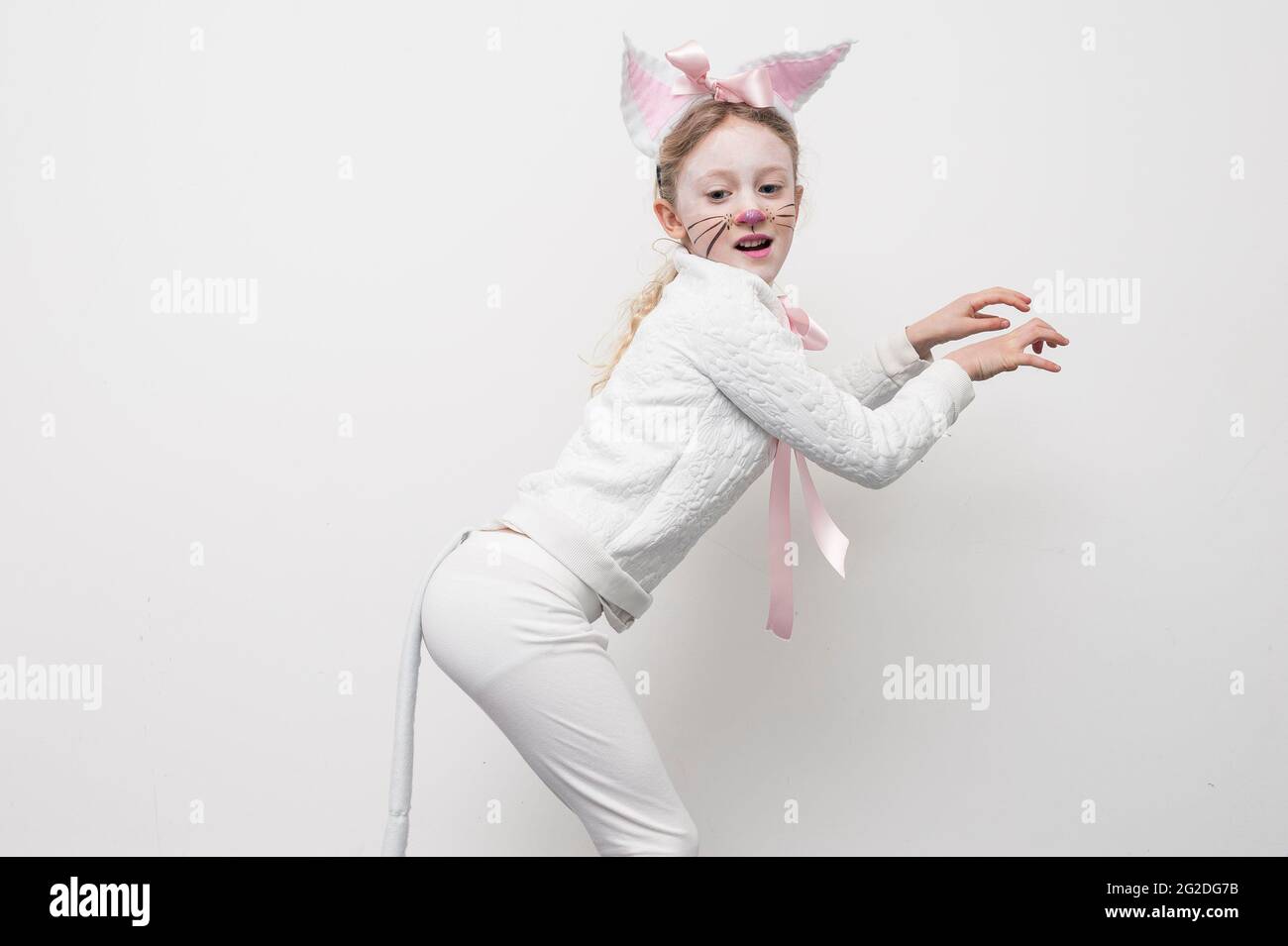 Ein junges Mädchen, das sich für den Weltbuchtag in einem Katzenkostüm verkleidet hat. Stockfoto