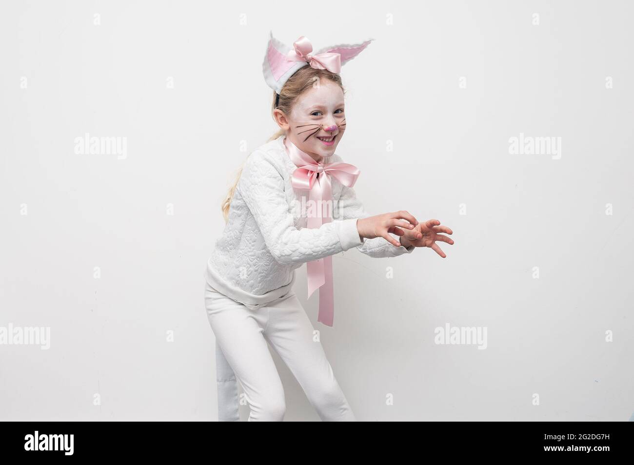 Ein junges Mädchen, das sich für den Weltbuchtag in einem Katzenkostüm verkleidet hat. Stockfoto