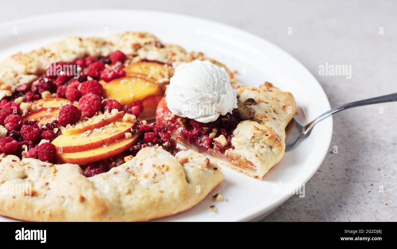 Himbeer- und Pfirsich-Torte, offener Kuchen auf hellem Hintergrund. Stockfoto