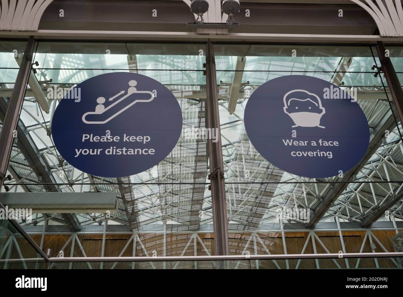 Passagiere und Mitarbeiter am Bahnhof Paddington in London tragen Masken und halten soziale Distanz wegen der COVID-19-Pandemie. England, Großbritannien. Stockfoto