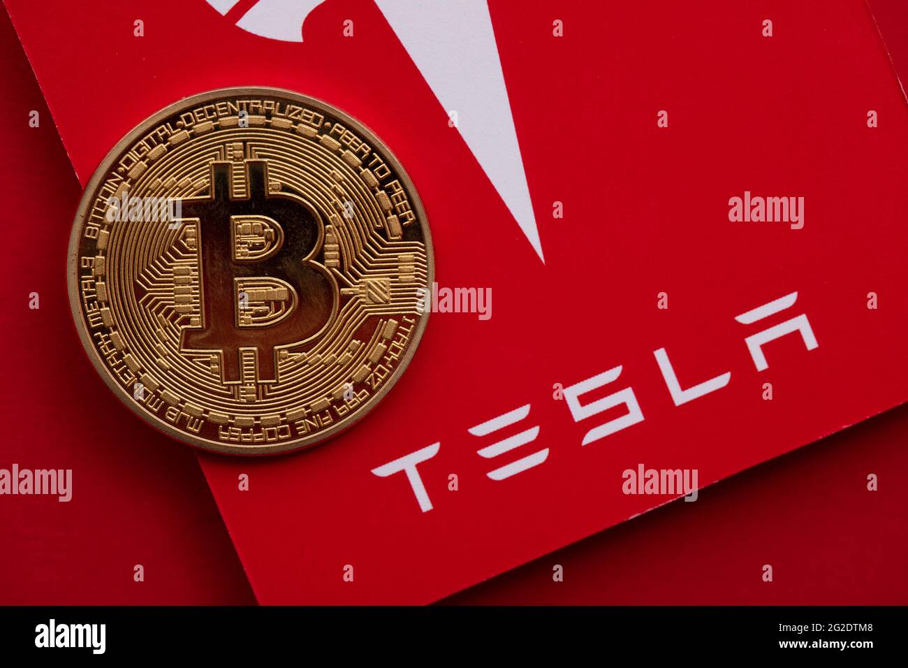 LONDON, Großbritannien - 2021. Juni: Bitcoin-Kryptowährung auf einem Tesla-Elektrofahrzeug-Logo Stockfoto