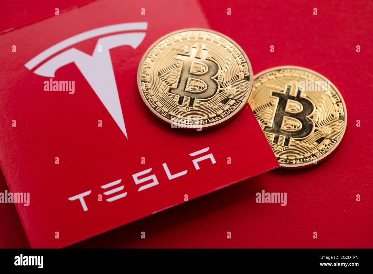 LONDON, Großbritannien - 2021. Juni: Bitcoin-Kryptowährung auf einem Tesla-Elektrofahrzeug-Logo Stockfoto