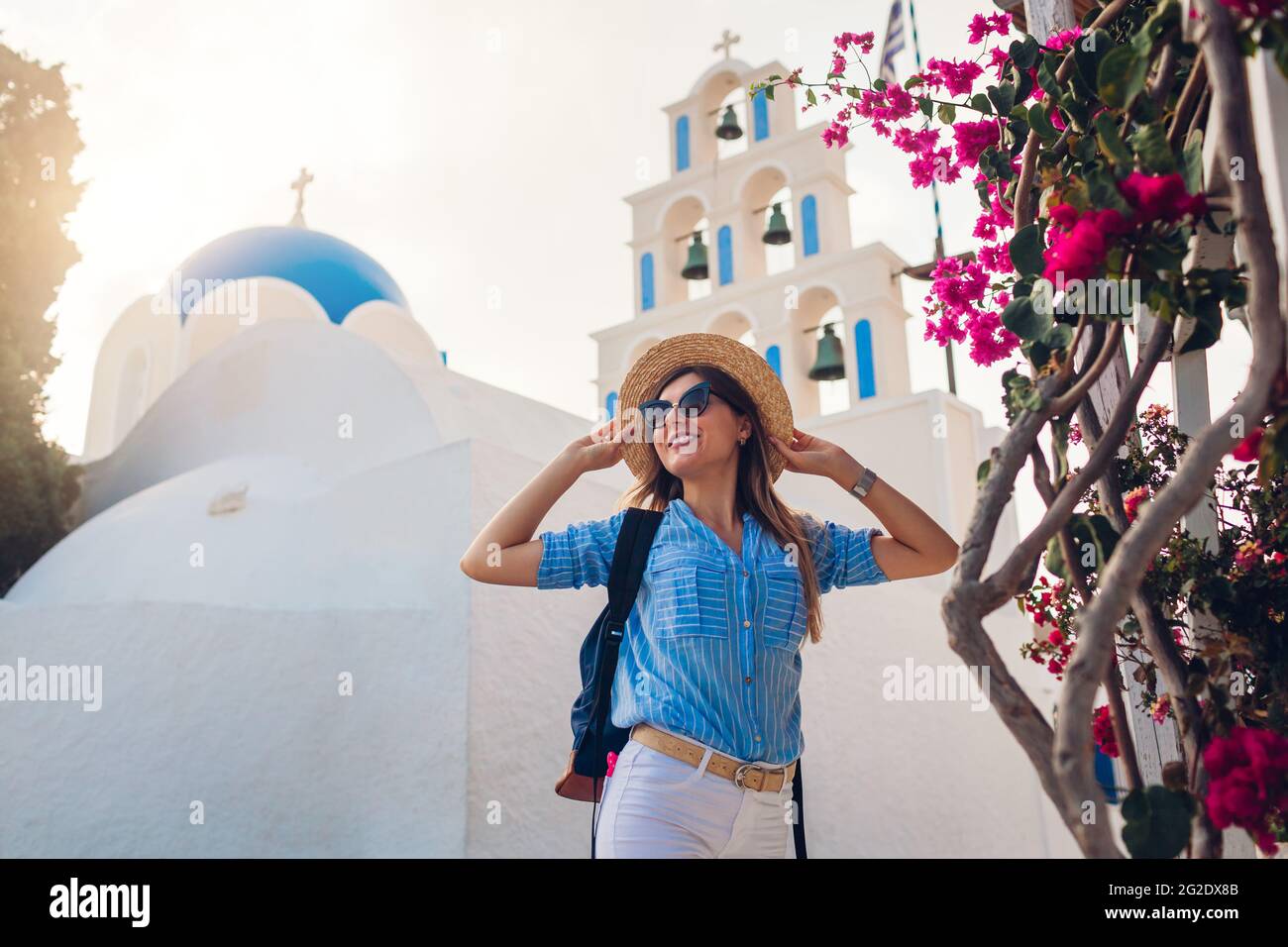 Santorini Tourist mit Rucksack Spaziergänge durch die Kirche mit blauer Kuppel und blühenden Bougainvillea Blumen in Akrotiri. Sommerurlaub Stockfoto Santorini Tourist mit Rucksack Spaziergänge durch die Kirche mit blauer Kuppel und blühenden Bougainvillea Blumen in Akrotiri. Sommerurlaub Stockfoto