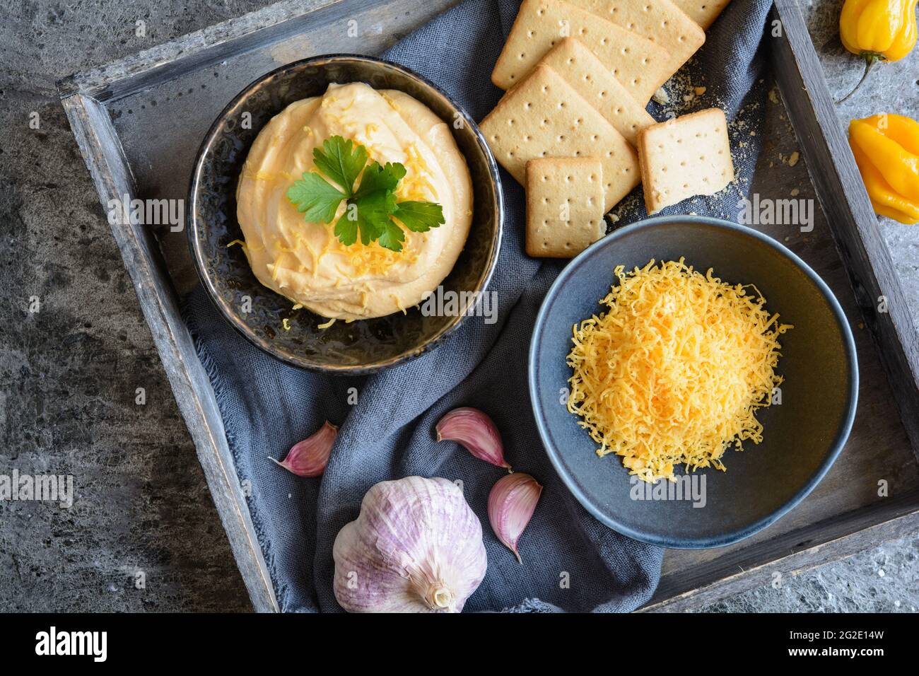 Einfache Cheddar-Käsedip mit Knoblauch, serviert mit Crackern Stockfoto