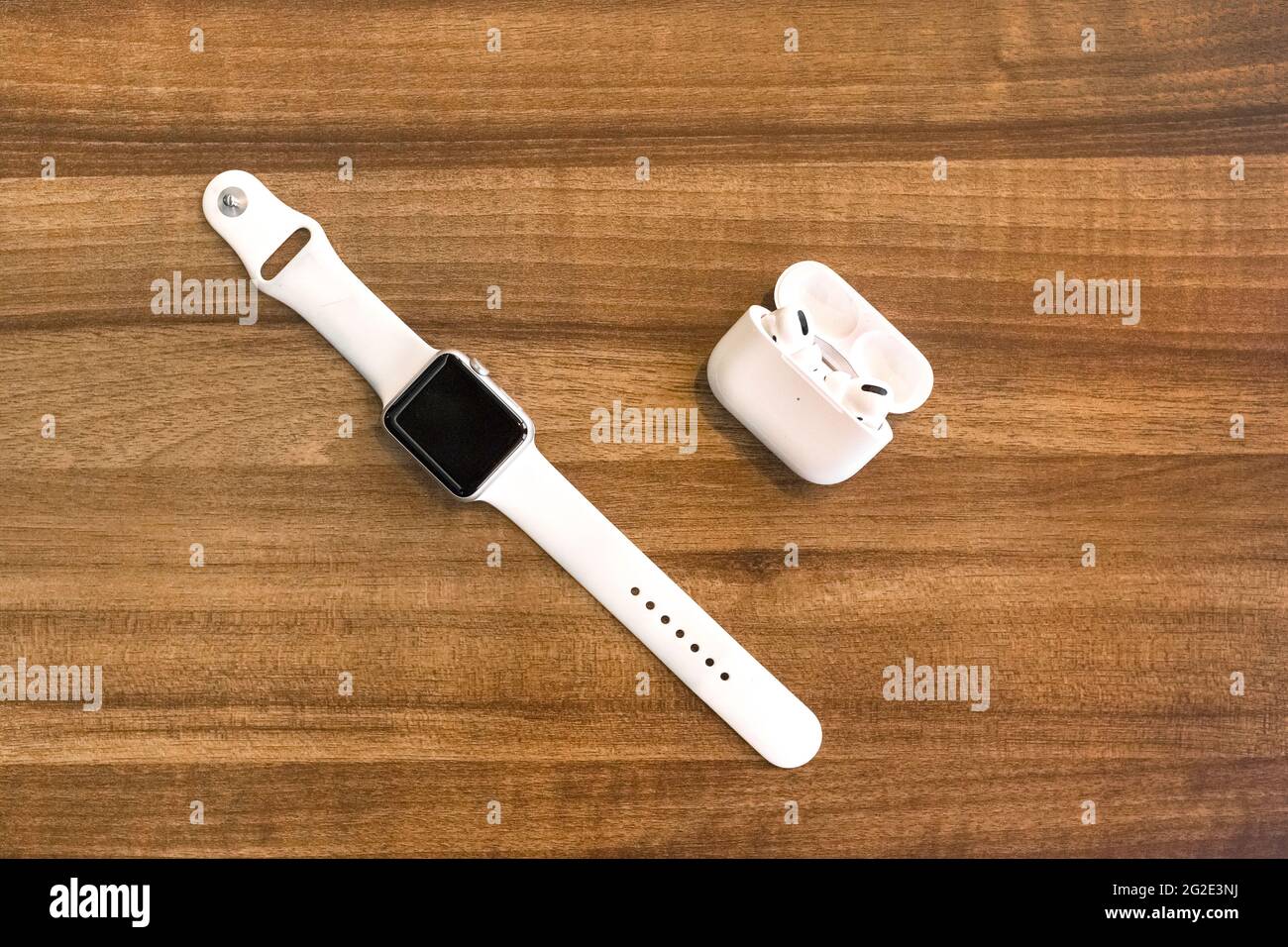 Weißrussland, Minsk Region - 17. März 2020: Apple Watch 4 und AirPods Kopfhörer auf Holzhintergrund. Stockfoto