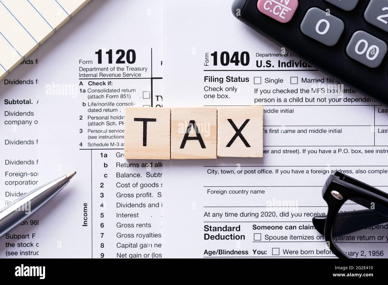 Steuerwort aus Holzfliesen. US-Steuerformular an der Rezeption. Konzept der Unternehmenssteuer-Einkünfte Stockfoto