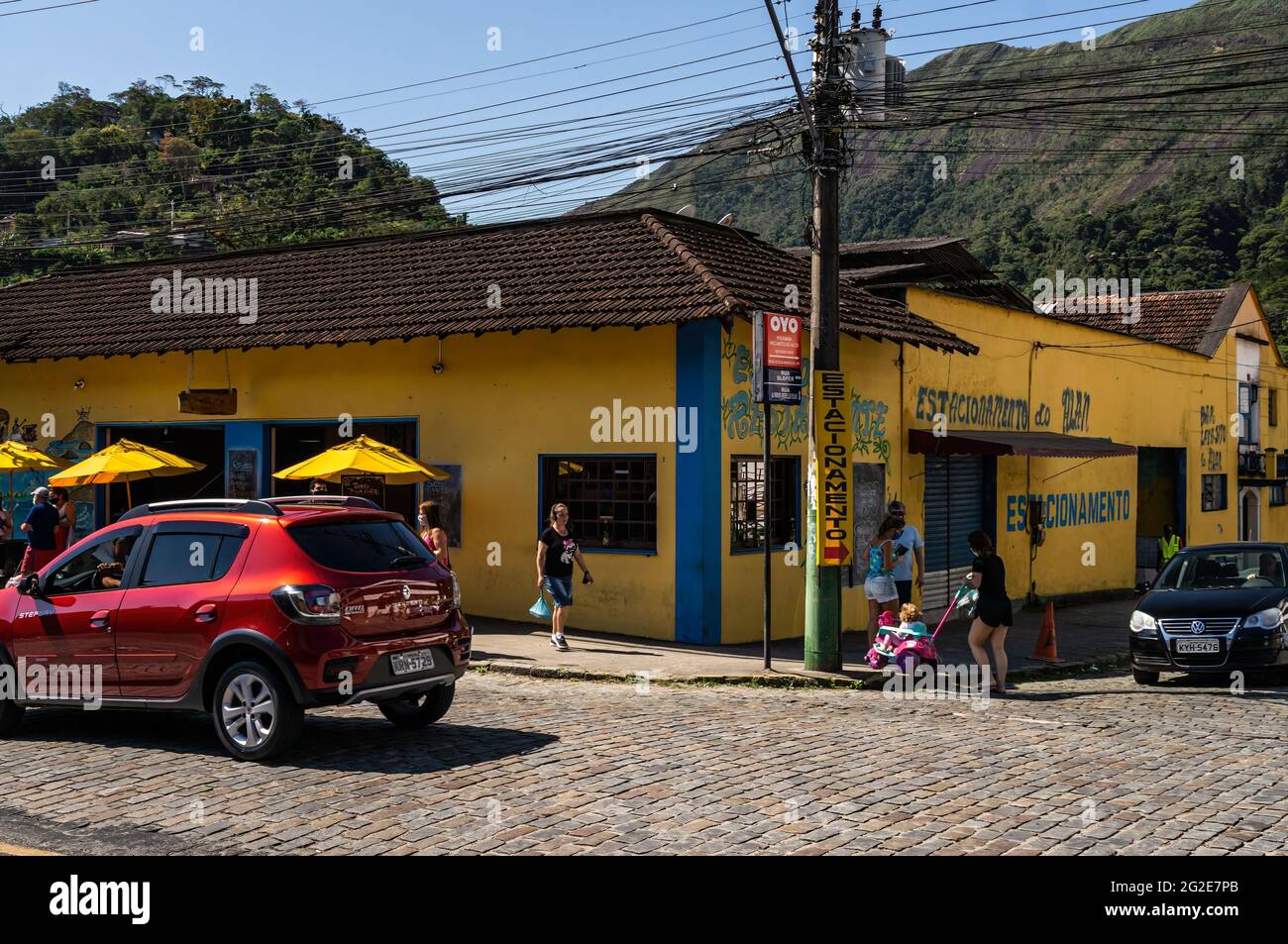 Ein gelbes Gebäude mit einem Restaurant und einer Parkgarage an der Ecke der Alfredo Rebelo Filho Straße mit Sloper Straße. Stockfoto