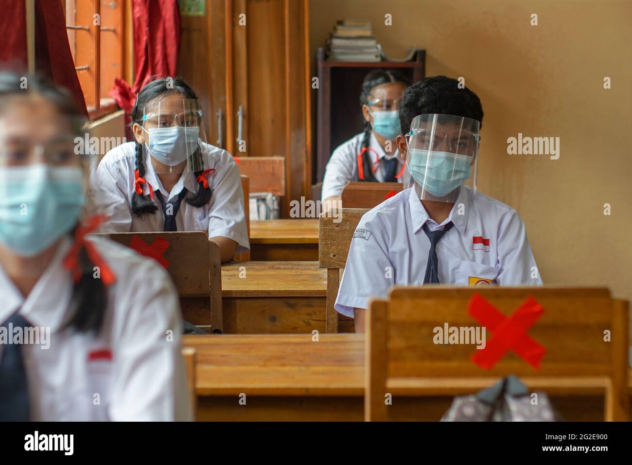 BALI, INDONESIEN-MAI 18 2021: Studenten in Indonesien verfolgen den Lernprozess im Unterricht mit Gesichtsschutz und Gesundheitsmasken, um Gesundheit p zu implementieren Stockfoto
