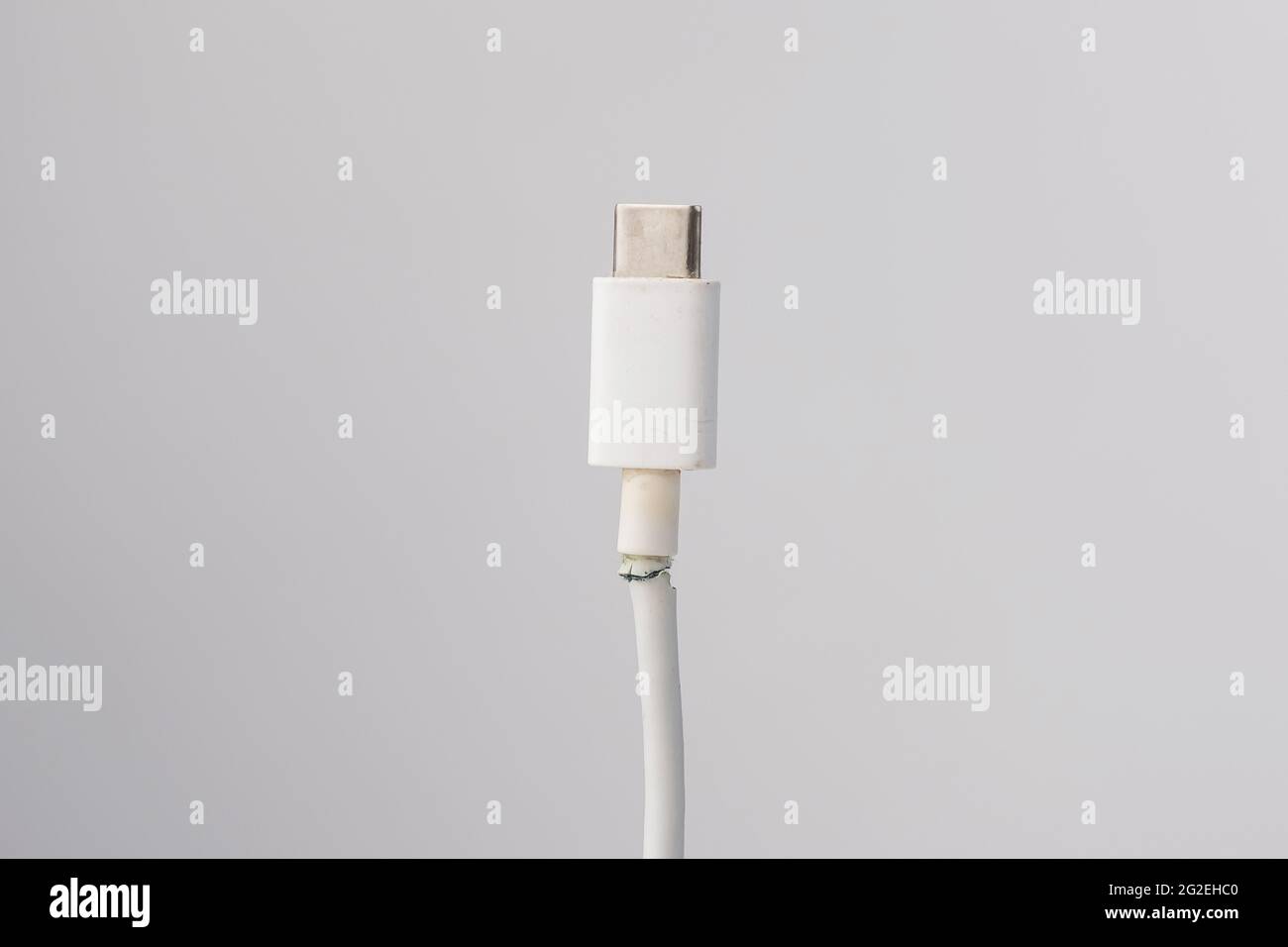 Abgerissenes Kabel zum Aufladen eines Mobiltelefons vom Typ si auf weißem Hintergrund. Speicherplatz kopieren. Stockfoto