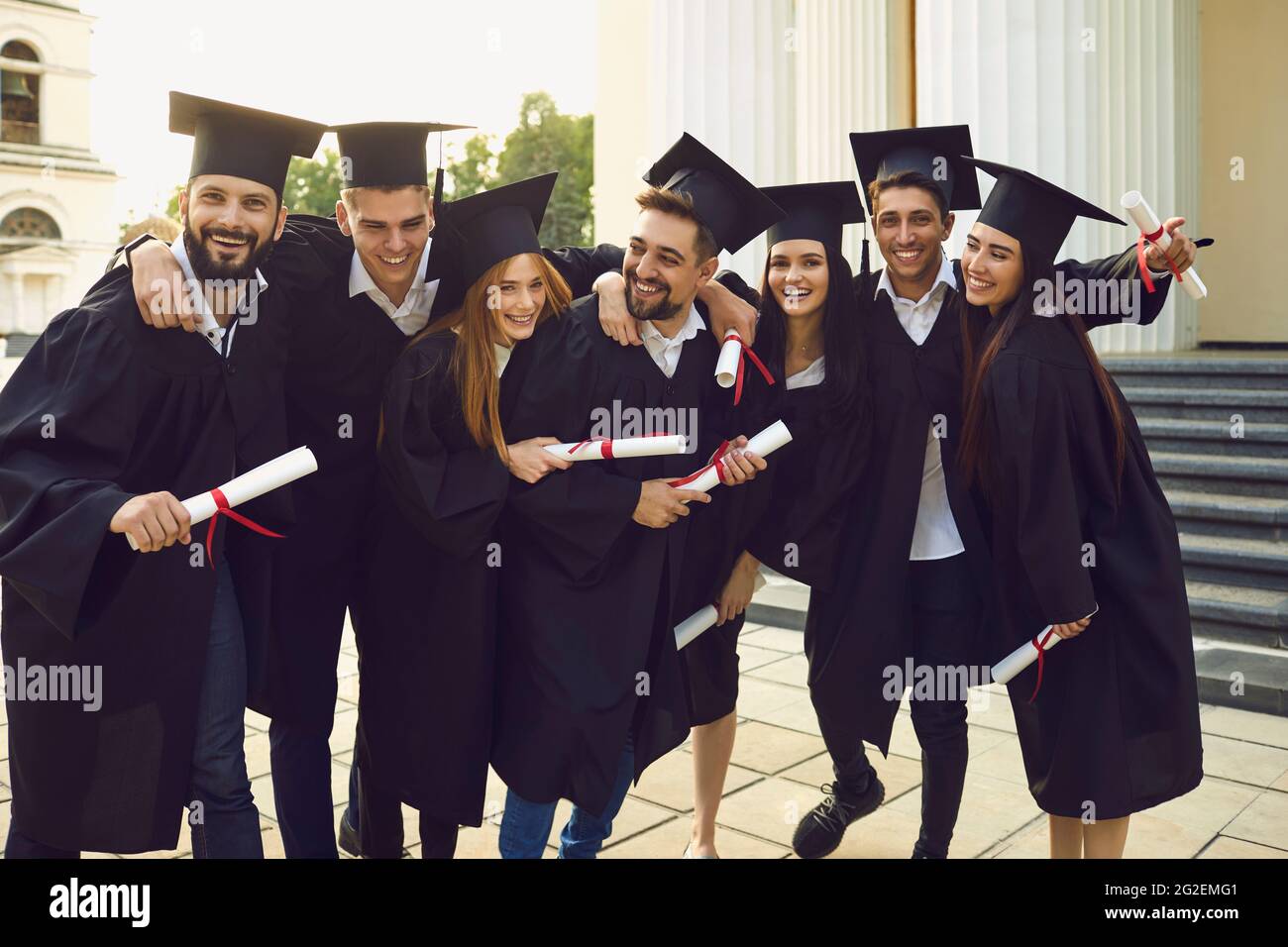 Die Gesellschaft der fröhlichen graduierten Menschen in der Nähe der Universität Stockfoto
