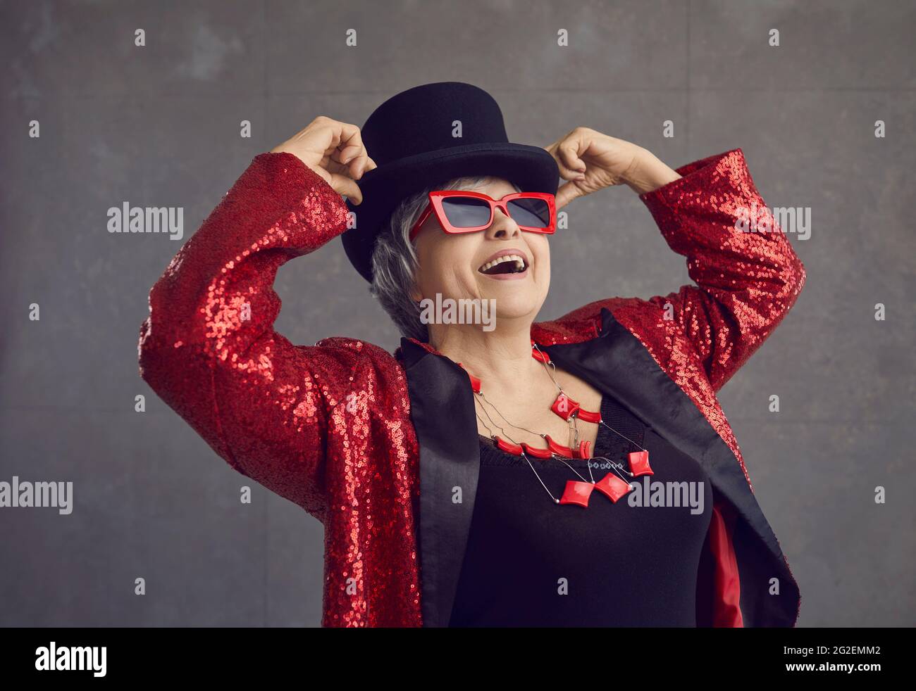 Porträt einer fröhlichen, coolen älteren Frau in einem funkigen Outfit, die sich auf einer Disco-Party amüsieren kann Stockfoto