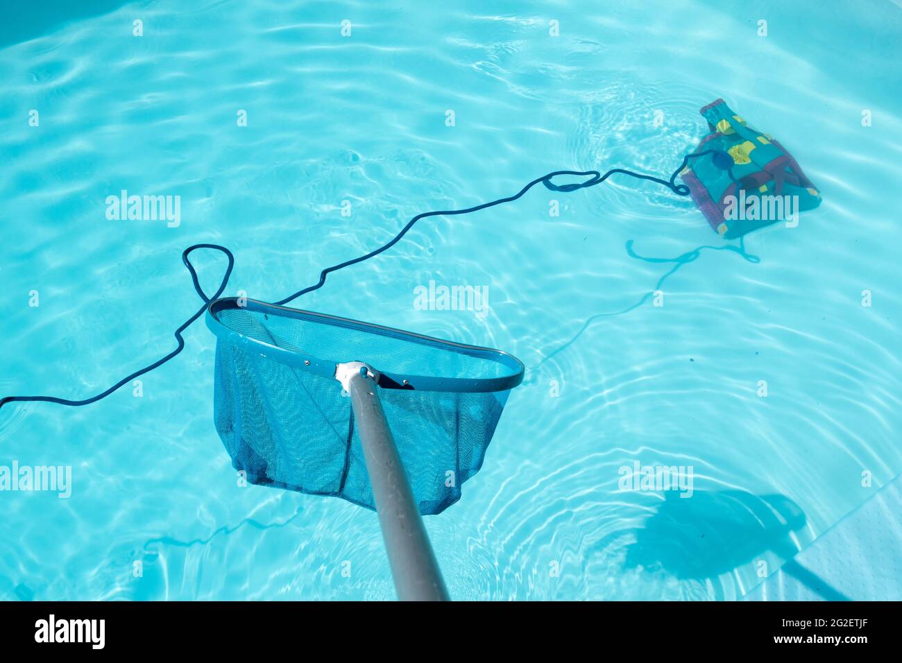 Schwimmbadreinigung mit Pool Skimmer und Unterwasserreinigungsroboter Stockfoto