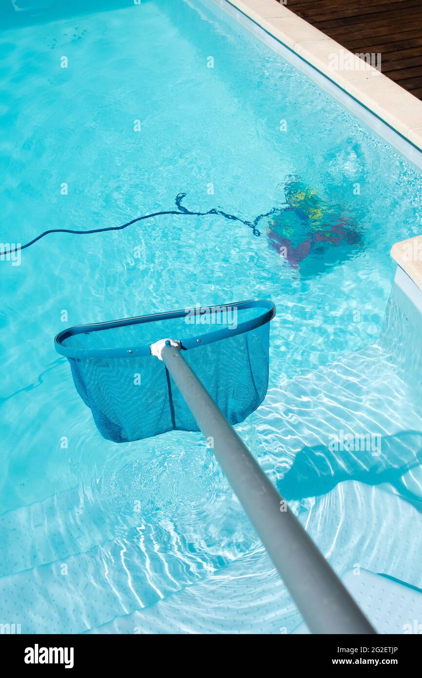 Schwimmbadreinigung mit Pool Skimmer und Unterwasserreinigungsroboter Stockfoto