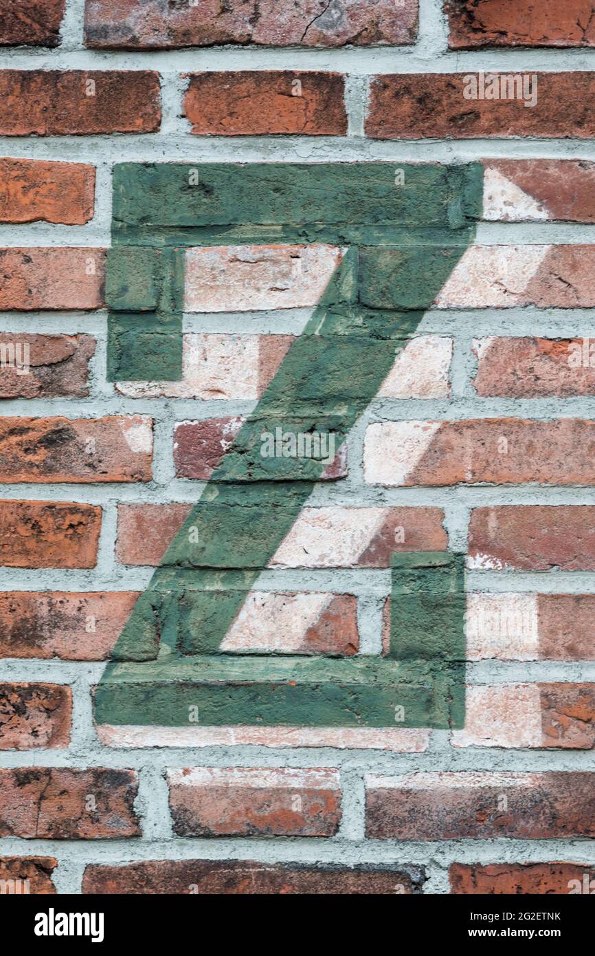 Ein grüner Buchstabe Z, gemalt auf einer roten Ziegelwand Stockfoto